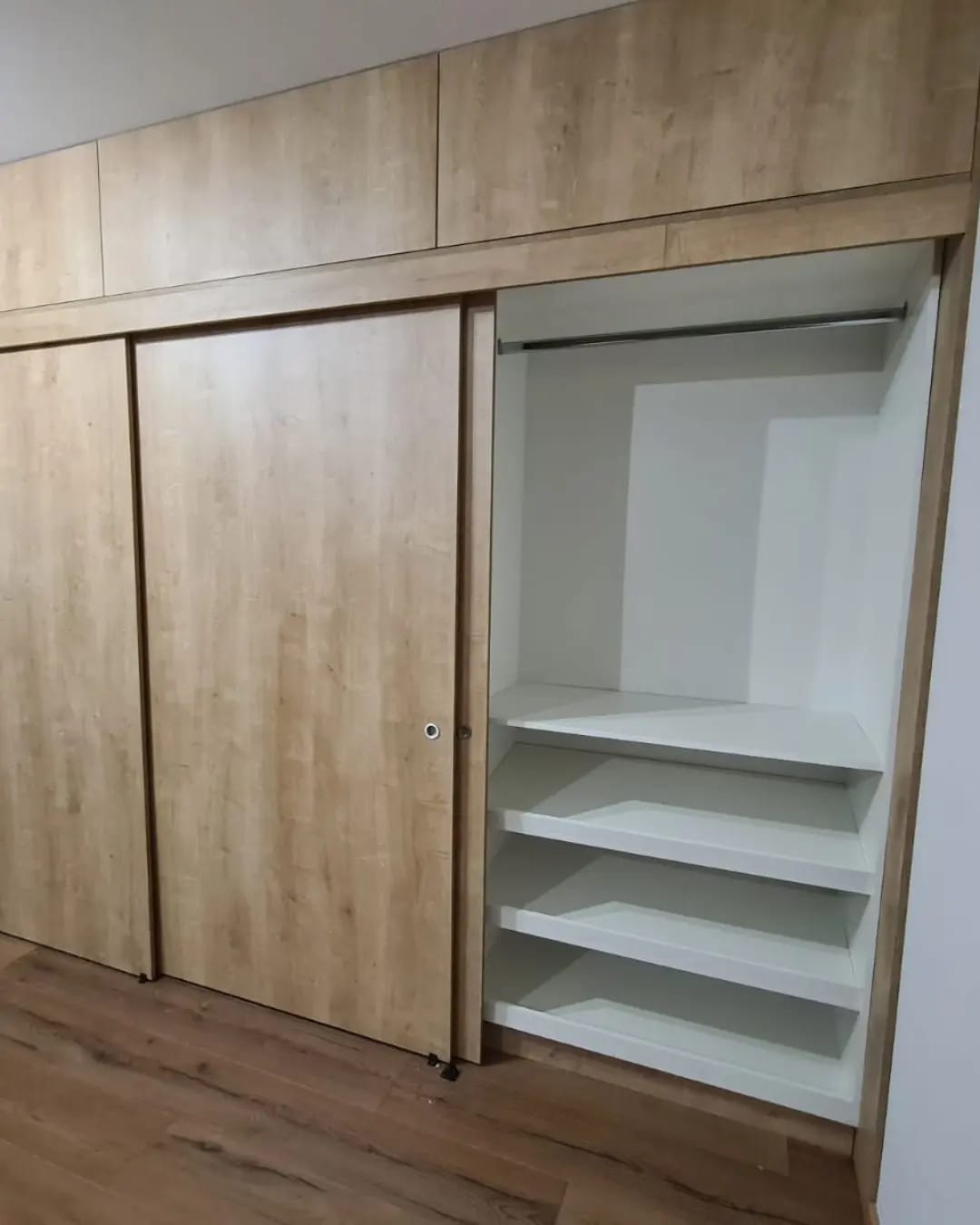 Closet madera clara corredera maleteros repisas